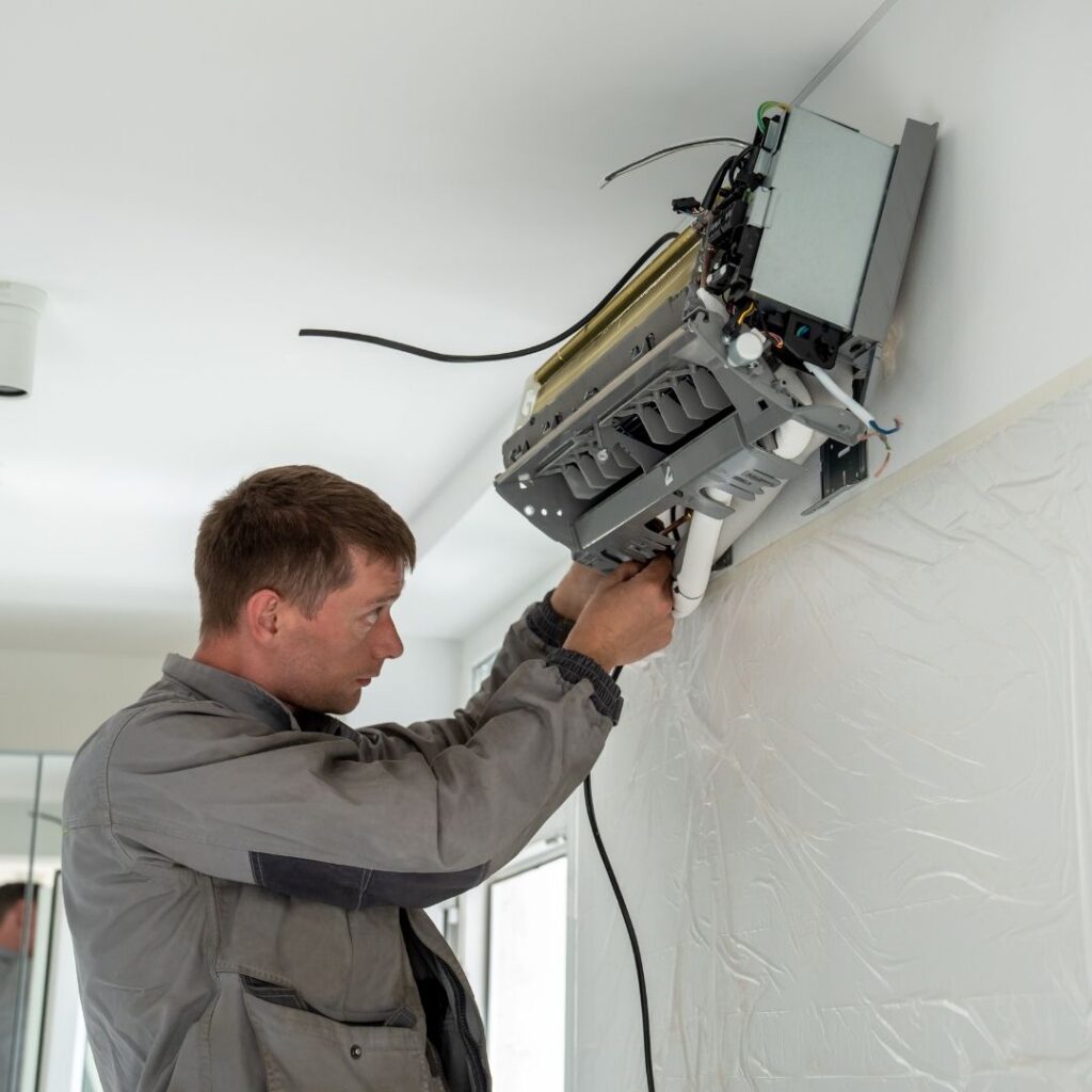 A technician using a digital multimeter to diagnose an electrical issue within a furnace as part of professional Furnace Services in Arizona.