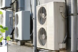 Multiple air conditioning units mounted on the side of a building, emphasizing the importance of professional Heating Repair Services in Arizona to ensure optimal system performance and home comfort.