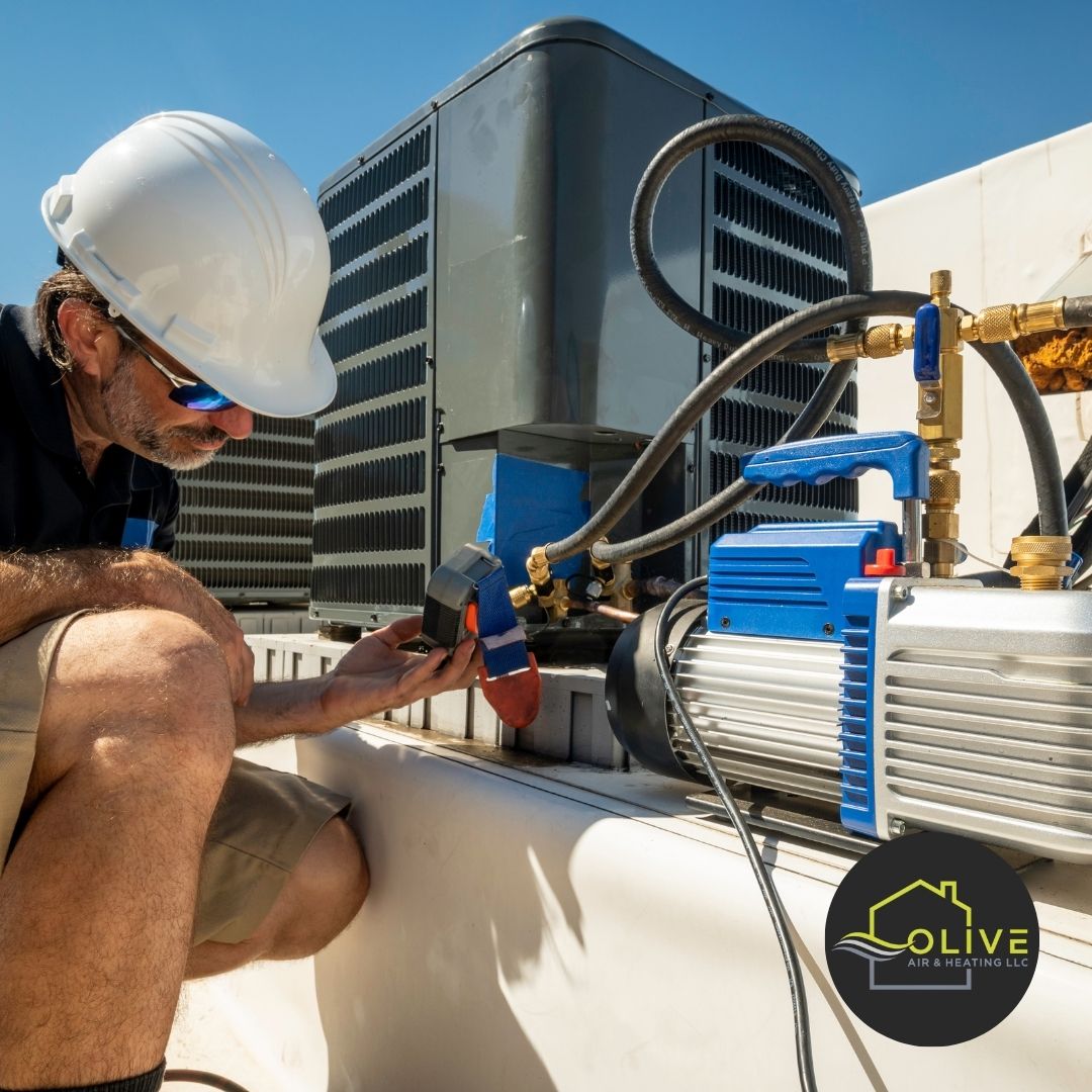 Technician checking refrigerant levels on an AC unit with vacuum pump