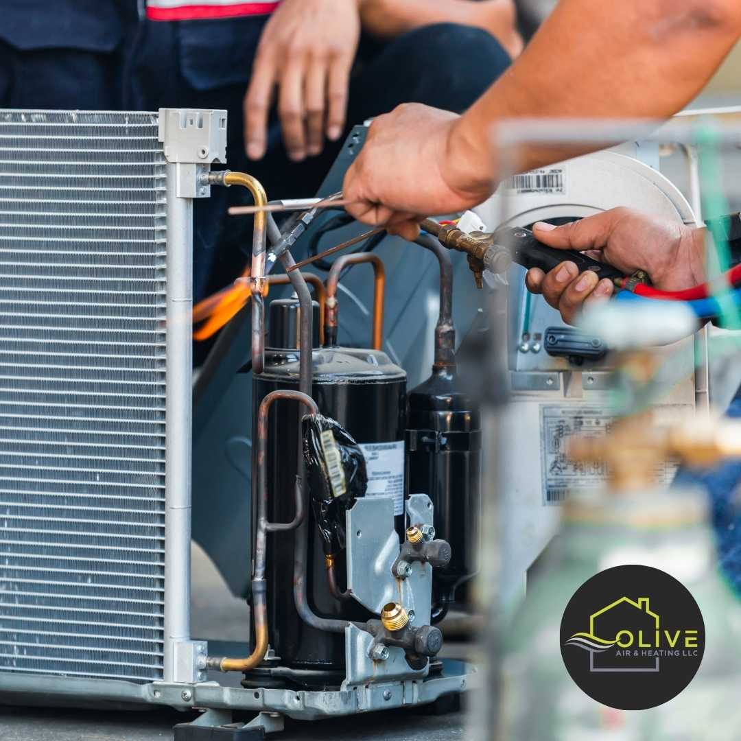 An Olive Air technician examining AC components for signs of wear to identify and address any AC repair needs effectively.