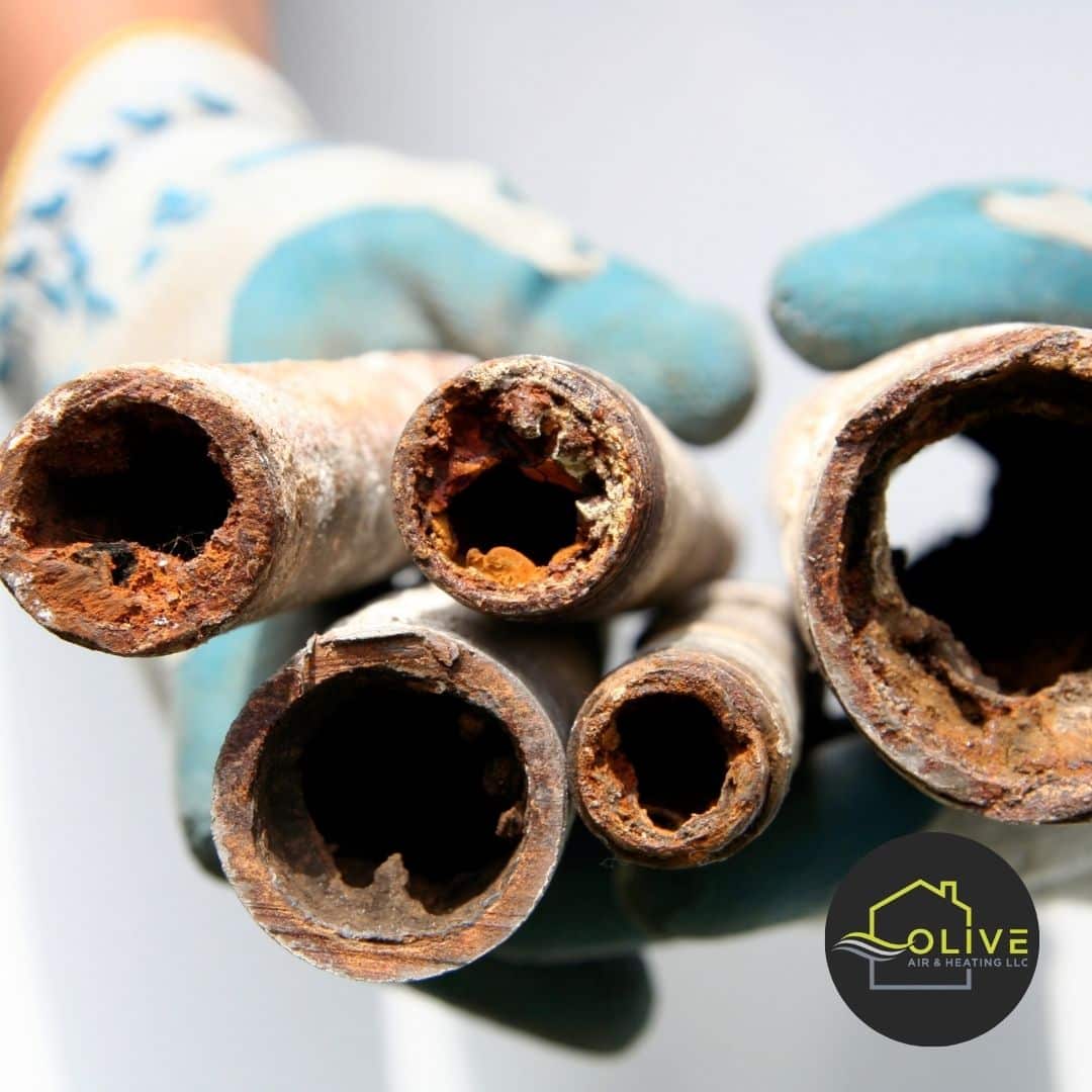 Close-up image of a clogged AC drainage system, showing algae and debris blocking the flow of water.