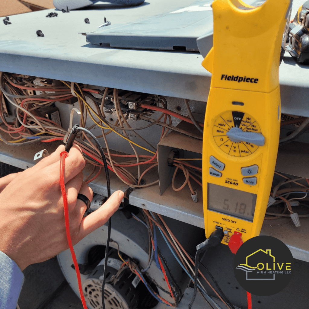 Technician diagnosing a faulty fan motor in an AC unit, preparing for a replacement.