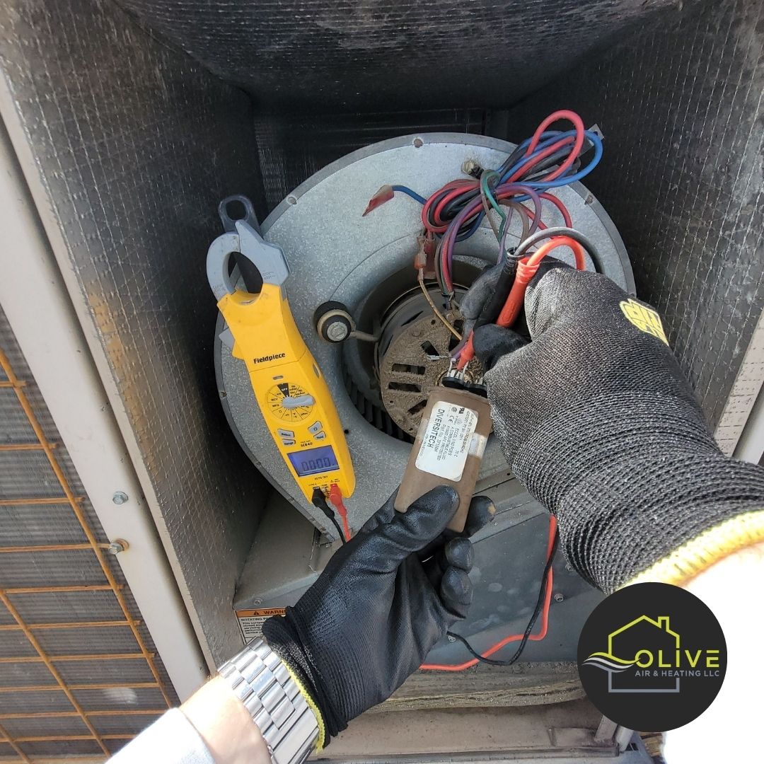  Close-up view of a faulty AC capacitor, showing signs of bulging and leakage, which can cause system malfunctions and reduced performance.