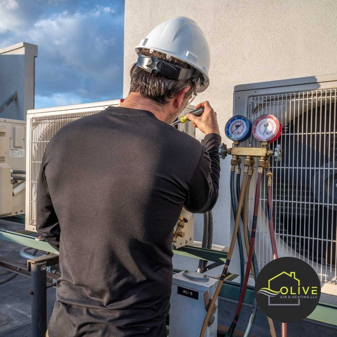 An Olive Air technician conducting a final inspection on an AC unit post-repair, confirming that all issues have been resolved and the system is functioning properly.