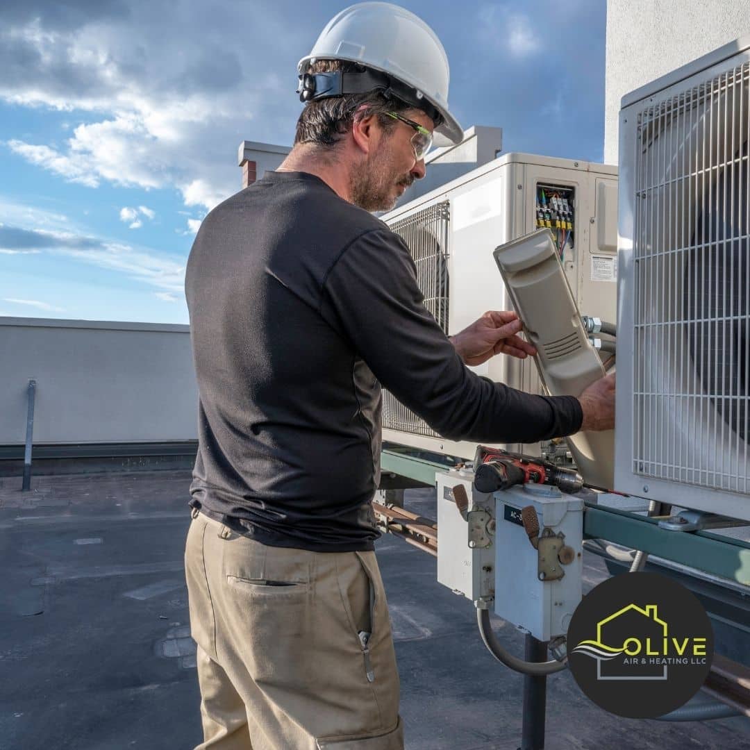 HVAC technician cleaning the drainage pan of an AC unit to remove debris and ensure proper water drainage in Tempe.