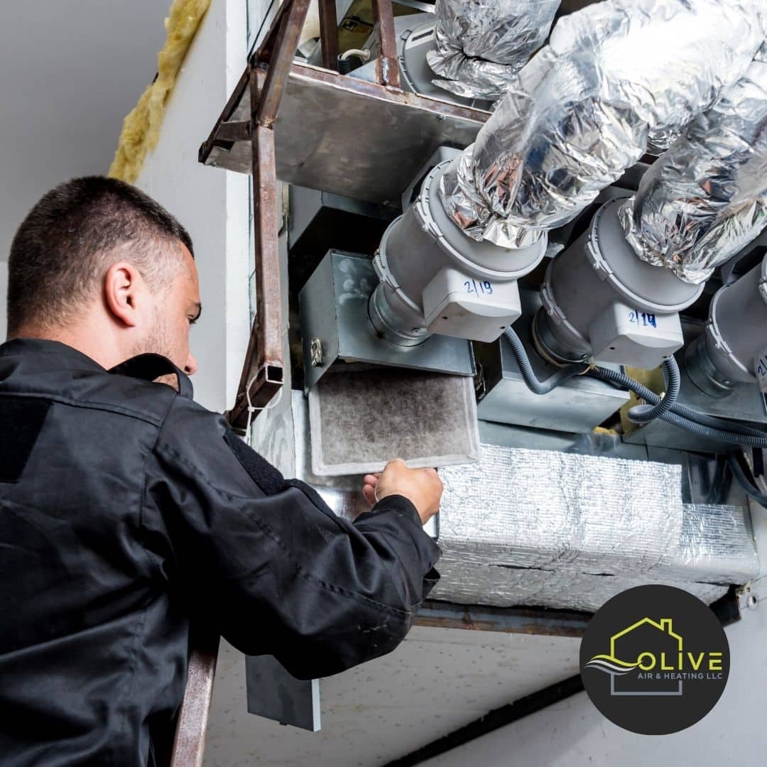  HVAC technician examining the drainage system of an AC unit in Tempe, checking for blockages and proper functionality to prevent water damage.