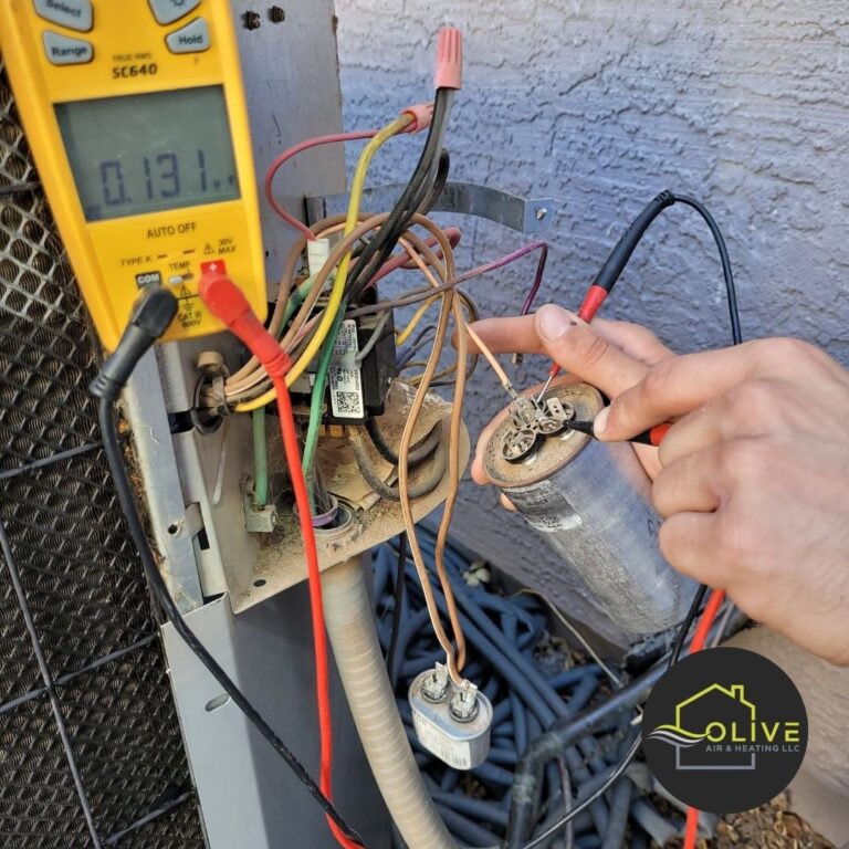 HVAC technician replacing a faulty AC capacitor in Queen Creek, AZ, to restore proper function and performance of the AC unit.