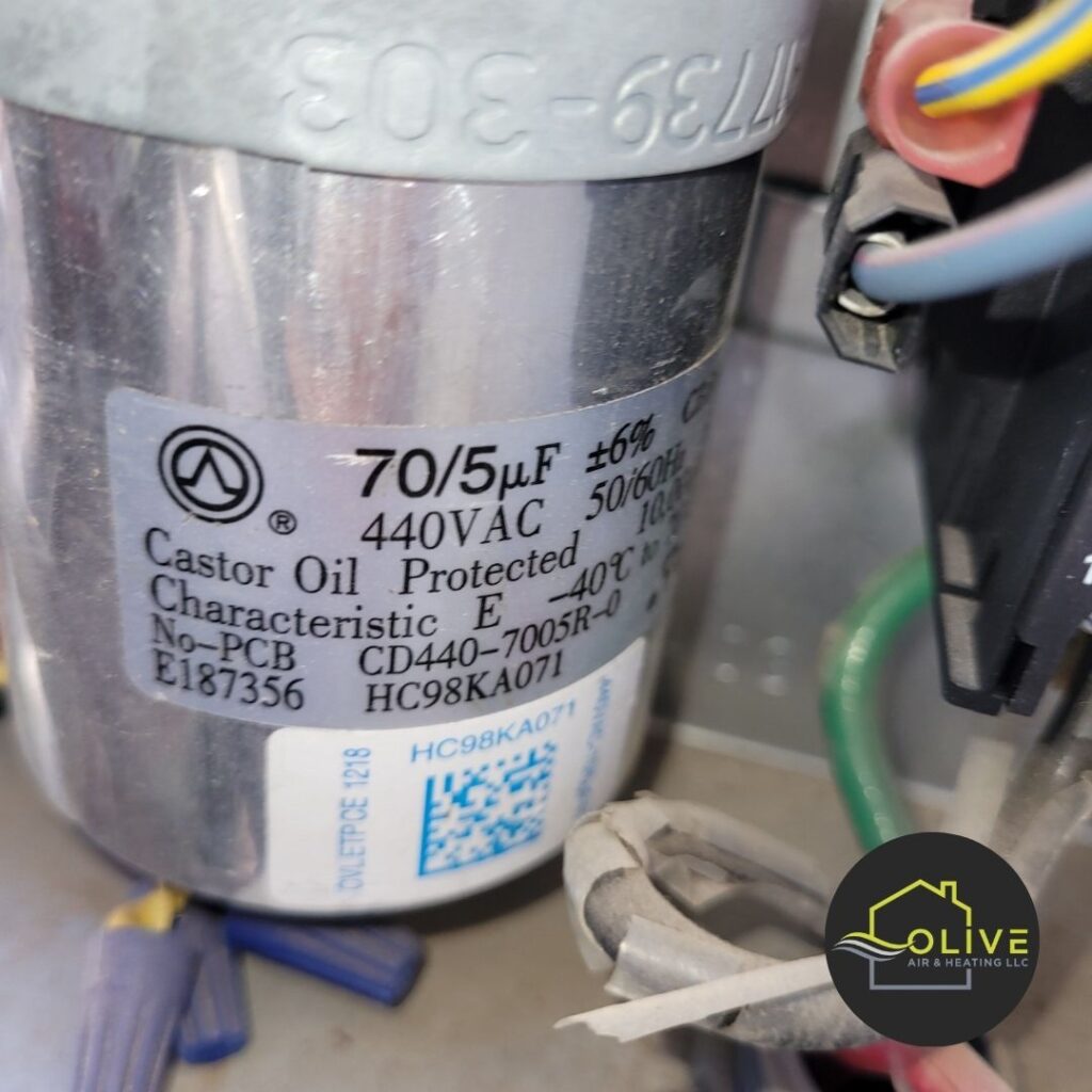 A close-up of an old and worn-out air conditioner capacitor, highlighting the importance of regular AC and Heating tune ups to identify and replace aging components