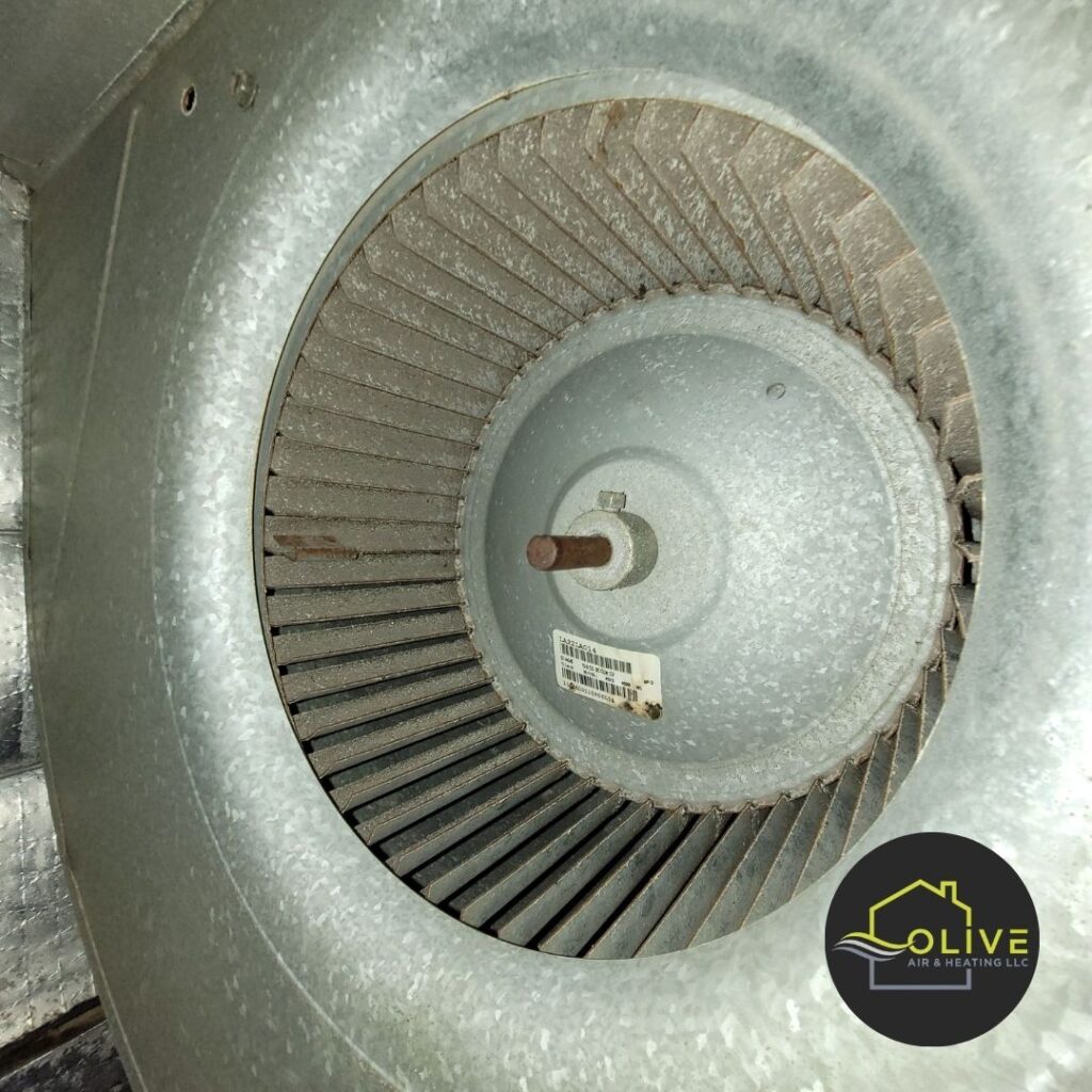 A close-up image of a severely clogged blower wheel, covered in a thick layer of dust, dirt, and debris. This can significantly reduce airflow, decrease heating system efficiency, and degrade indoor air quality. Regular HVAC maintenance can help keep the blower wheel clean and running smoothly. Heating repair