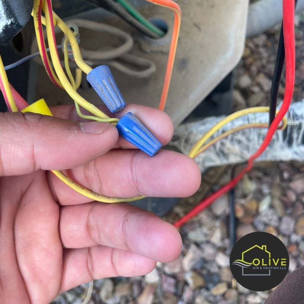 A technician inspecting a poorly connected wire nut in an air conditioning unit, highlighting the importance of professional AC repair to prevent electrical hazards and ensure optimal performance.