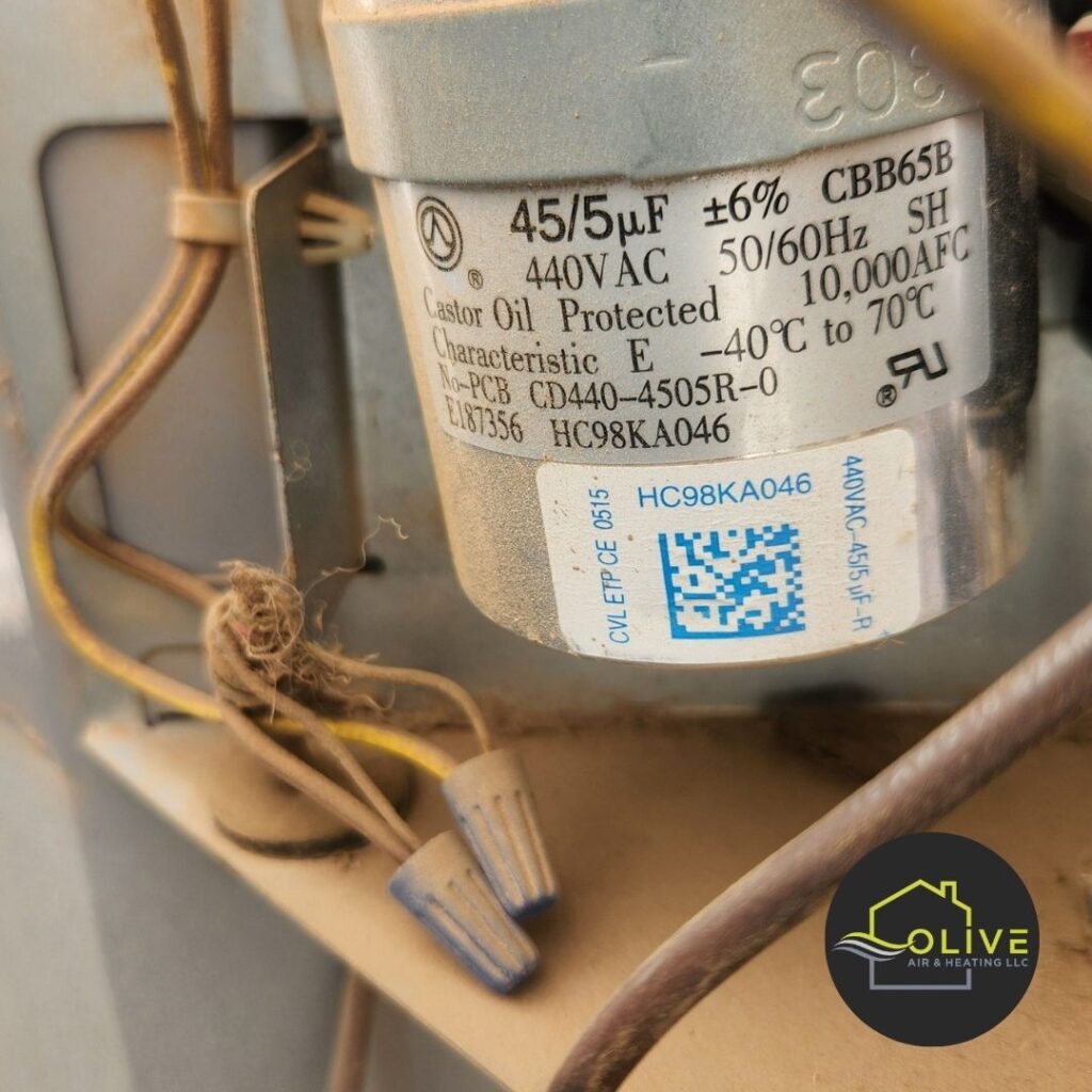 A close-up image of a technician inspecting the electrical components of an AC unit, including the capacitor and wiring. Regular maintenance and inspections can help identify potential electrical issues and prevent safety hazards. Ac and Heating Tune Up