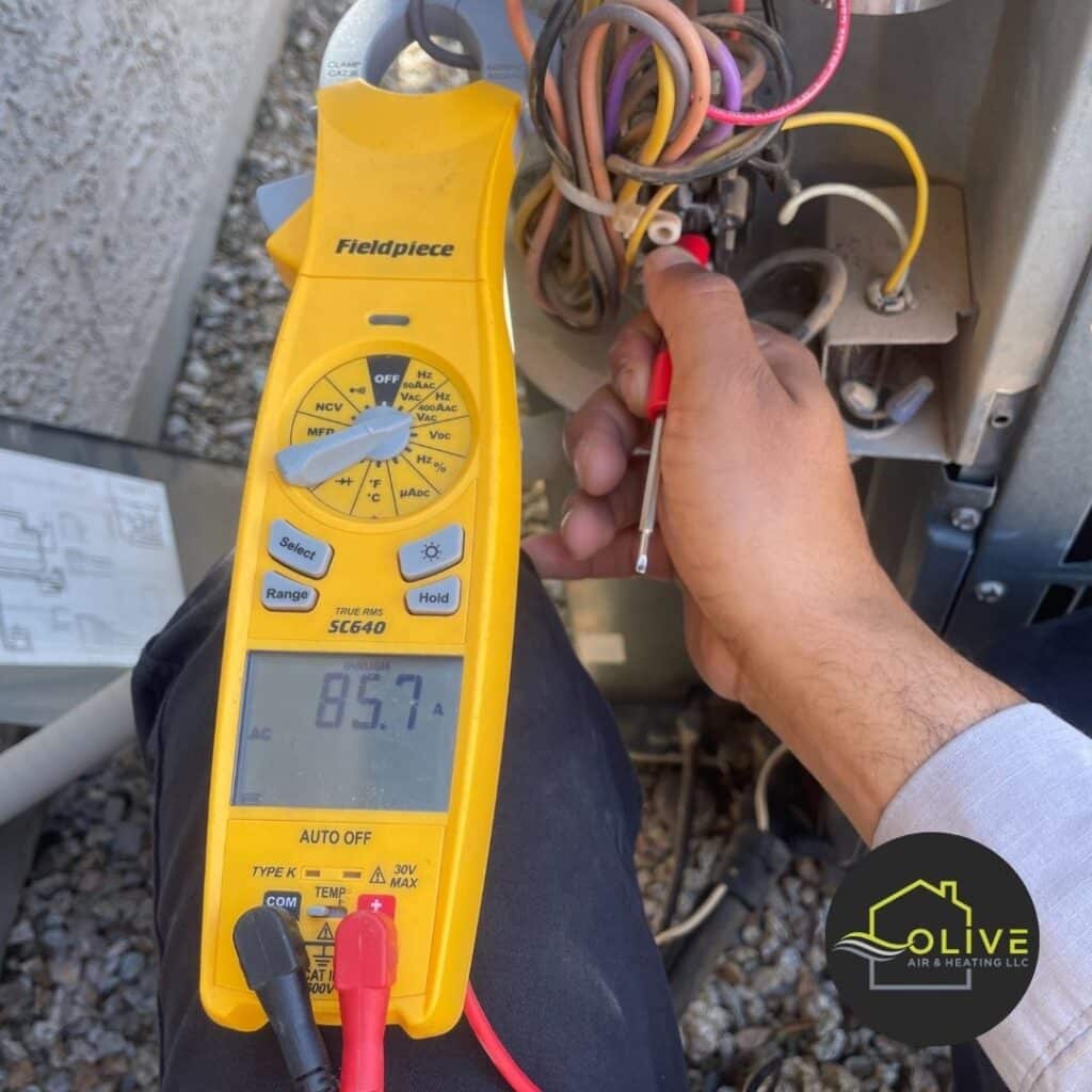 A technician using a digital multimeter to diagnose an air conditioning unit in Mesa, Arizona, ensuring accurate troubleshooting and efficient repairs. AC Repair Mesa