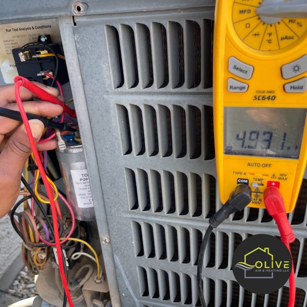 A technician using a digital multimeter to diagnose an air conditioning unit in Mesa, Arizona, as part of a preventive maintenance check-up. AC Tune Up Mesa