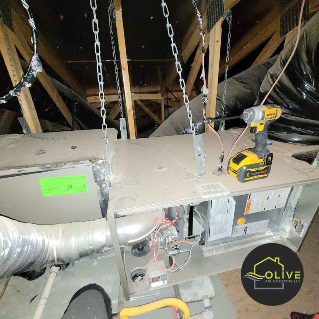 A technician inspecting the internal components of an AC unit located in an attic. Regular maintenance and inspections can help prevent unexpected breakdowns and ensure optimal performance.