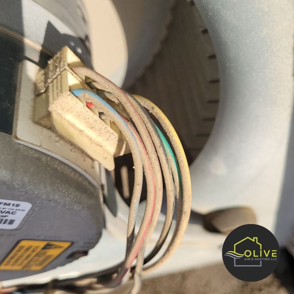 close-up image of worn and frayed electrical wiring on a heating system component. This can lead to electrical shorts, fires, and system malfunctions. Regular HVAC maintenance can help identify and repair faulty wiring.