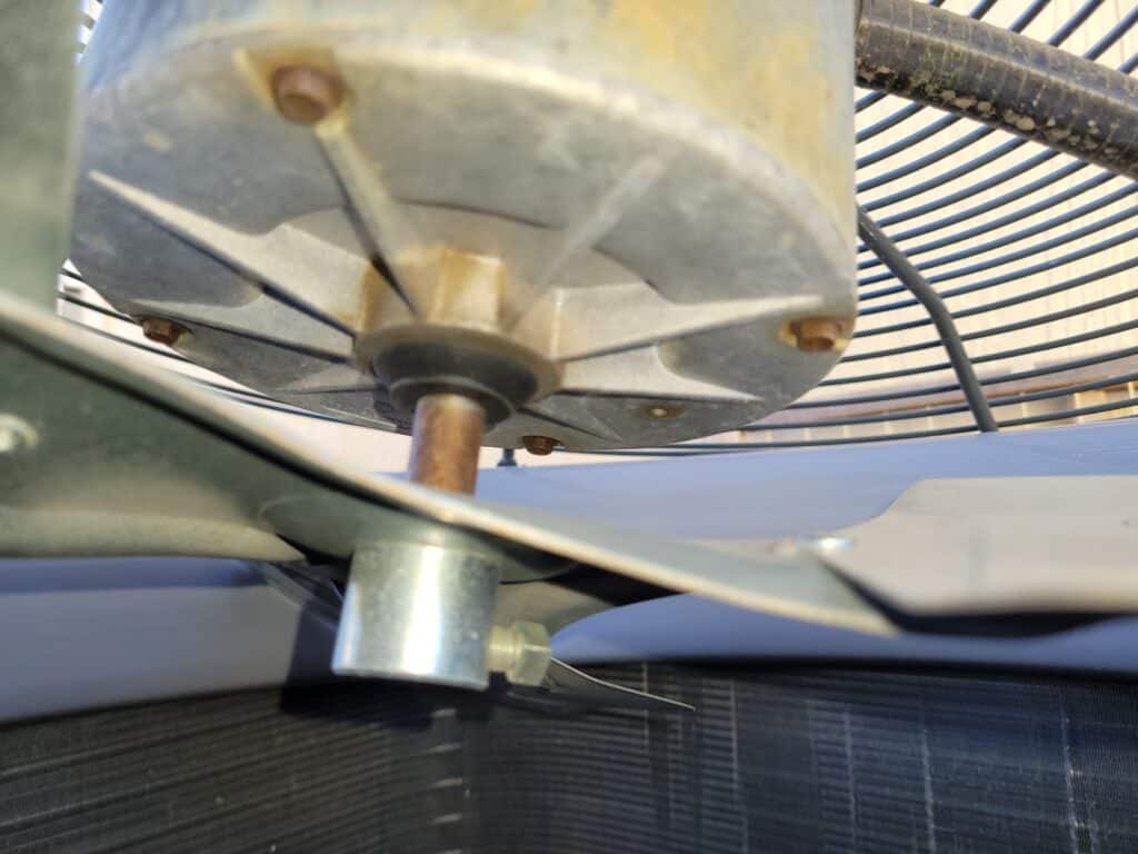 close-up of a worn-out air conditioner fan motor, highlighting the importance of early AC repair and maintenance to prevent breakdowns during peak summer months