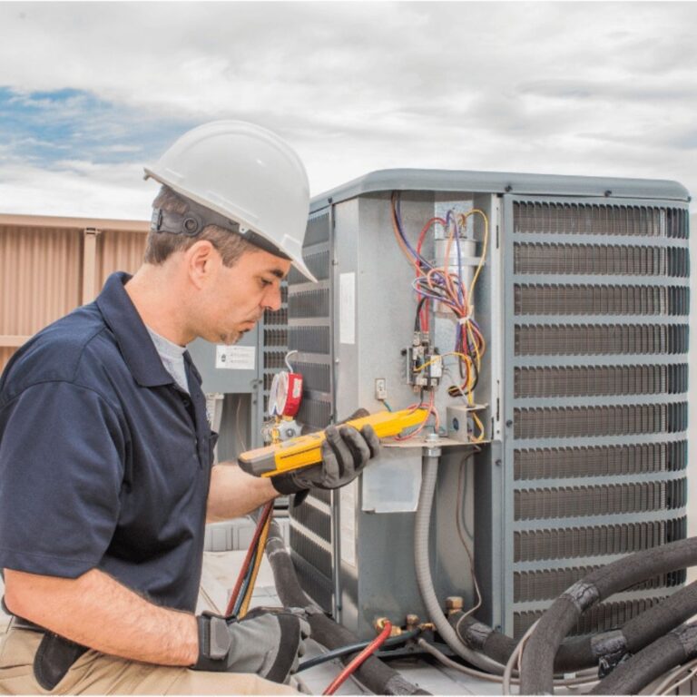 A technician using a digital multimeter to diagnose an electrical issue within a furnace as part of professional Furnace Services in Apache Junction.