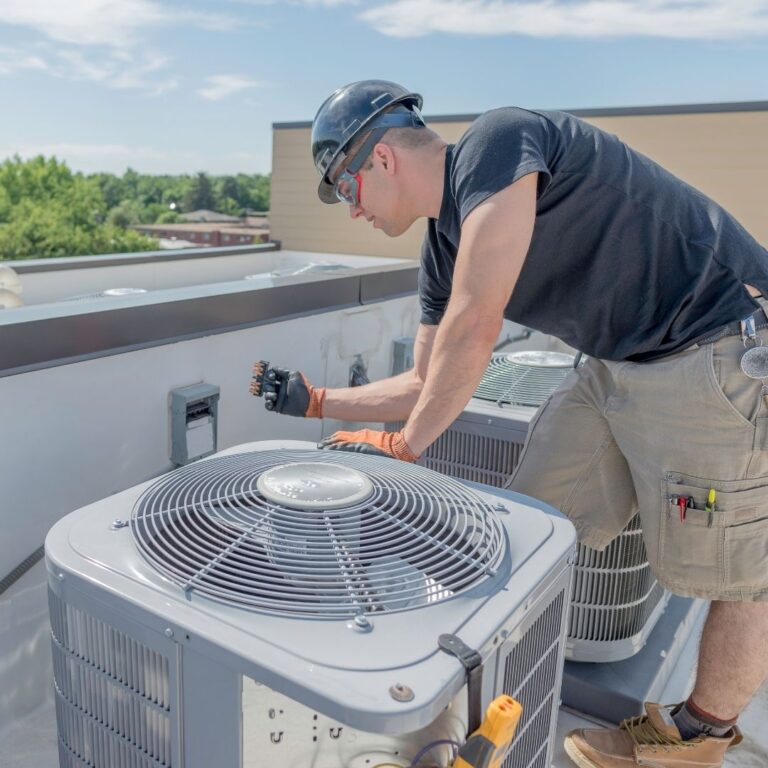 A technician using a digital multimeter to diagnose an electrical issue within a heat pump as part of professional Heat Pump Services in Avondale.