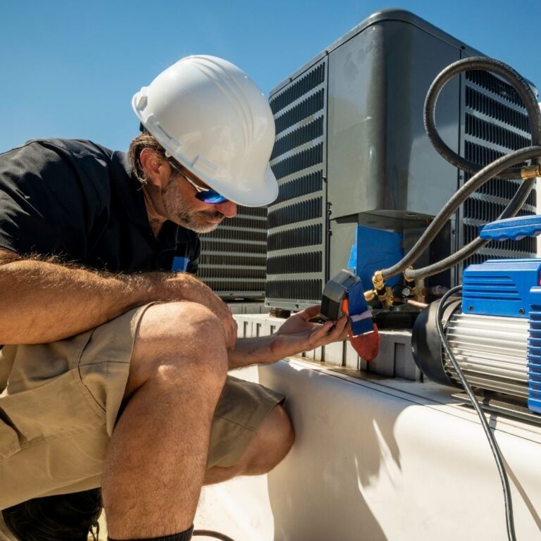 A technician using a digital multimeter to diagnose an electrical issue within a heat pump as part of professional Heat Pump Services in Coolidge.