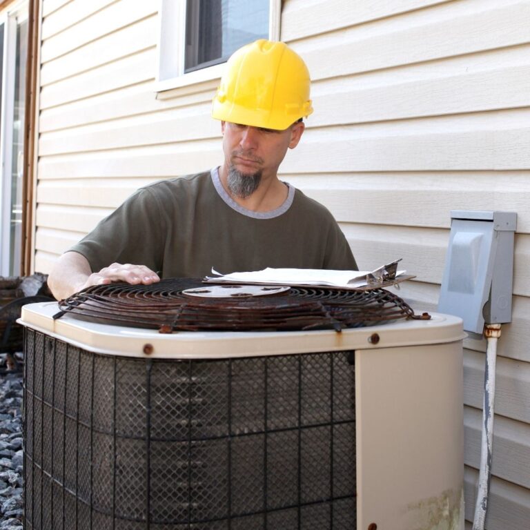 A technician using a digital multimeter to diagnose an electrical issue within a heat pump as part of professional Heat Pump Services in Peoria.