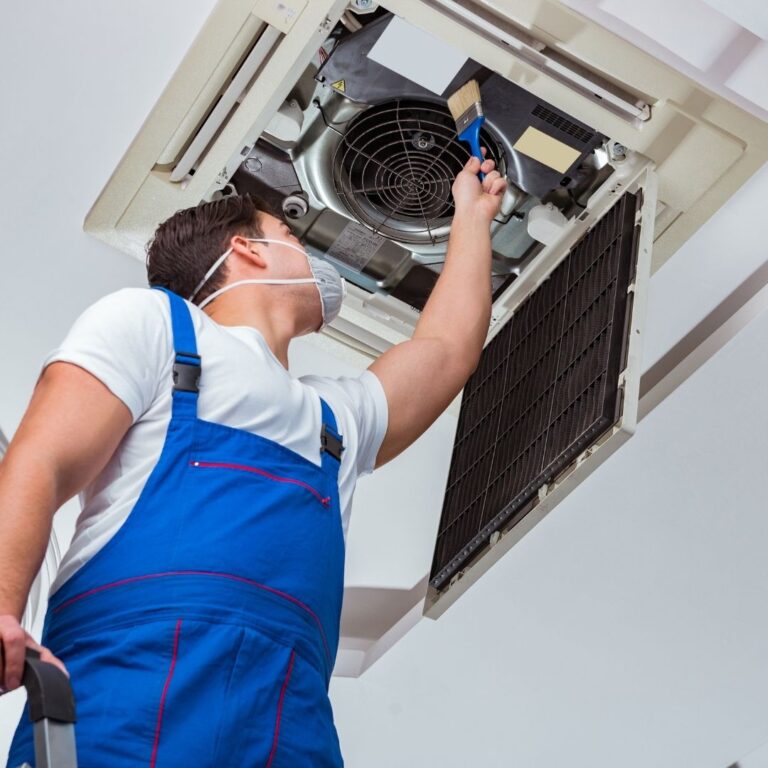 A qualified HVAC technician inspecting a heat pump unit as part of professional Heat Pump Services in Apache Junction, ensuring optimal performance and energy efficiency.