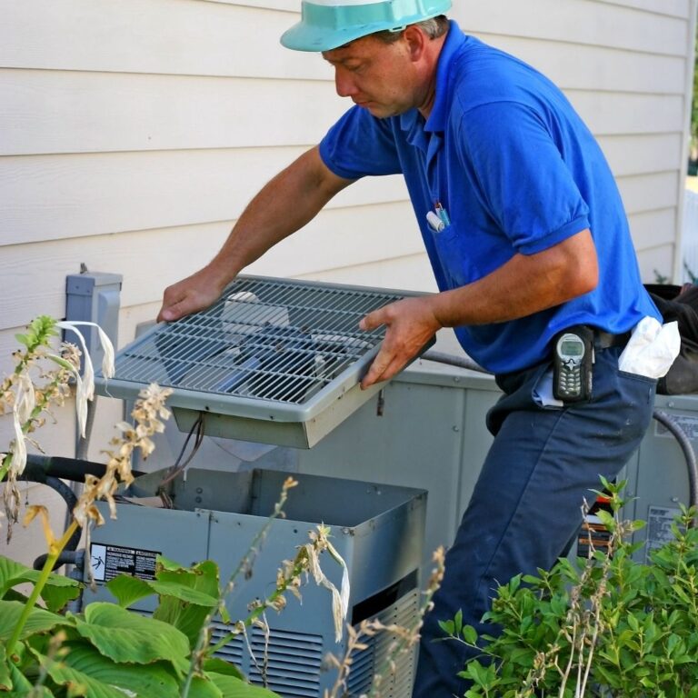 A qualified HVAC technician inspecting a heat pump unit as part of professional Heat Pump Services in Florence, ensuring optimal performance and energy efficiency.