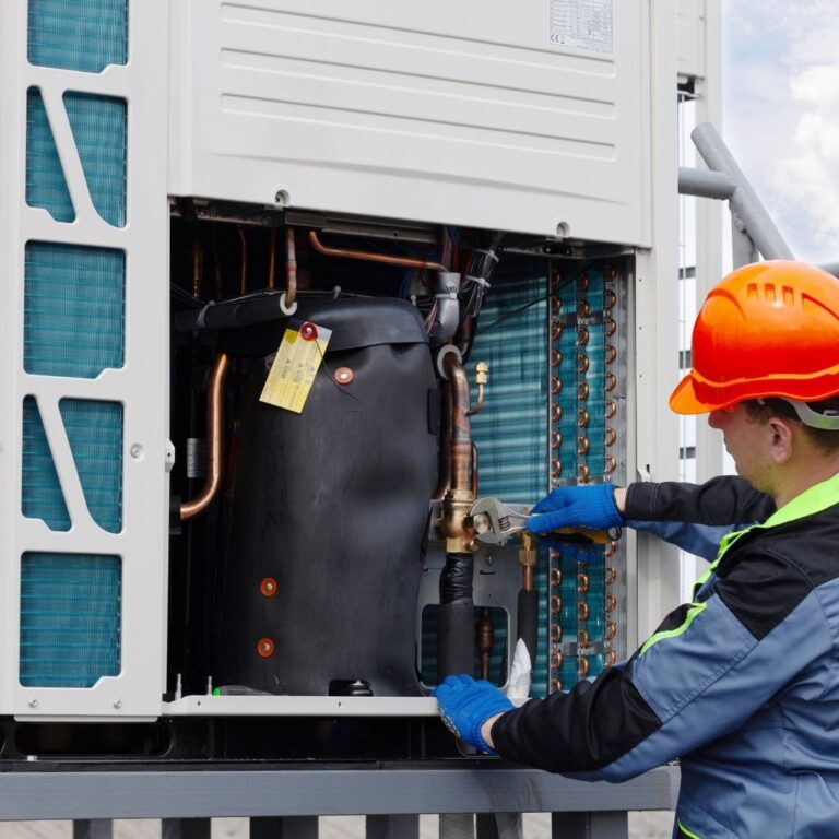 A qualified HVAC technician inspecting a heat pump unit as part of professional Heat Pump Services in Paradise Valley, ensuring optimal performance and energy efficiency.