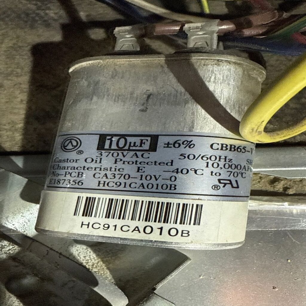 A close-up of an old air conditioning unit capacitor, a common component that can fail and require AC repair.