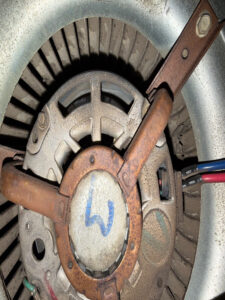 A close-up of a rusty and worn-out AC fan motor, highlighting the need for professional AC repair to prevent further damage and ensure optimal cooling.