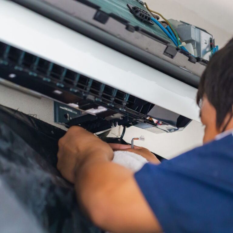 A technician using a digital multimeter to diagnose an electrical issue within a furnace as part of professional Furnace Services in Fountain Hills.