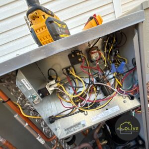 Close-up of an HVAC technician inspecting the electrical panel during an HVAC tune up service in Mesa, Arizona.