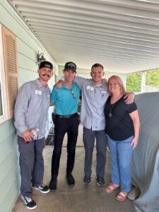 Olive Air & Heating technicians posing with happy homeowners after providing expert AC repair services in Gilbert, AZ.